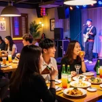 상봉동 한국관나이트 lively atmosphere with people enjoying cocktails and K-pop performance.